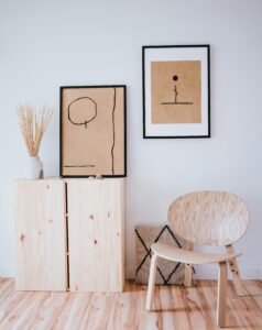A serene Japandi interior with minimalist wooden furniture and art on a white wall.